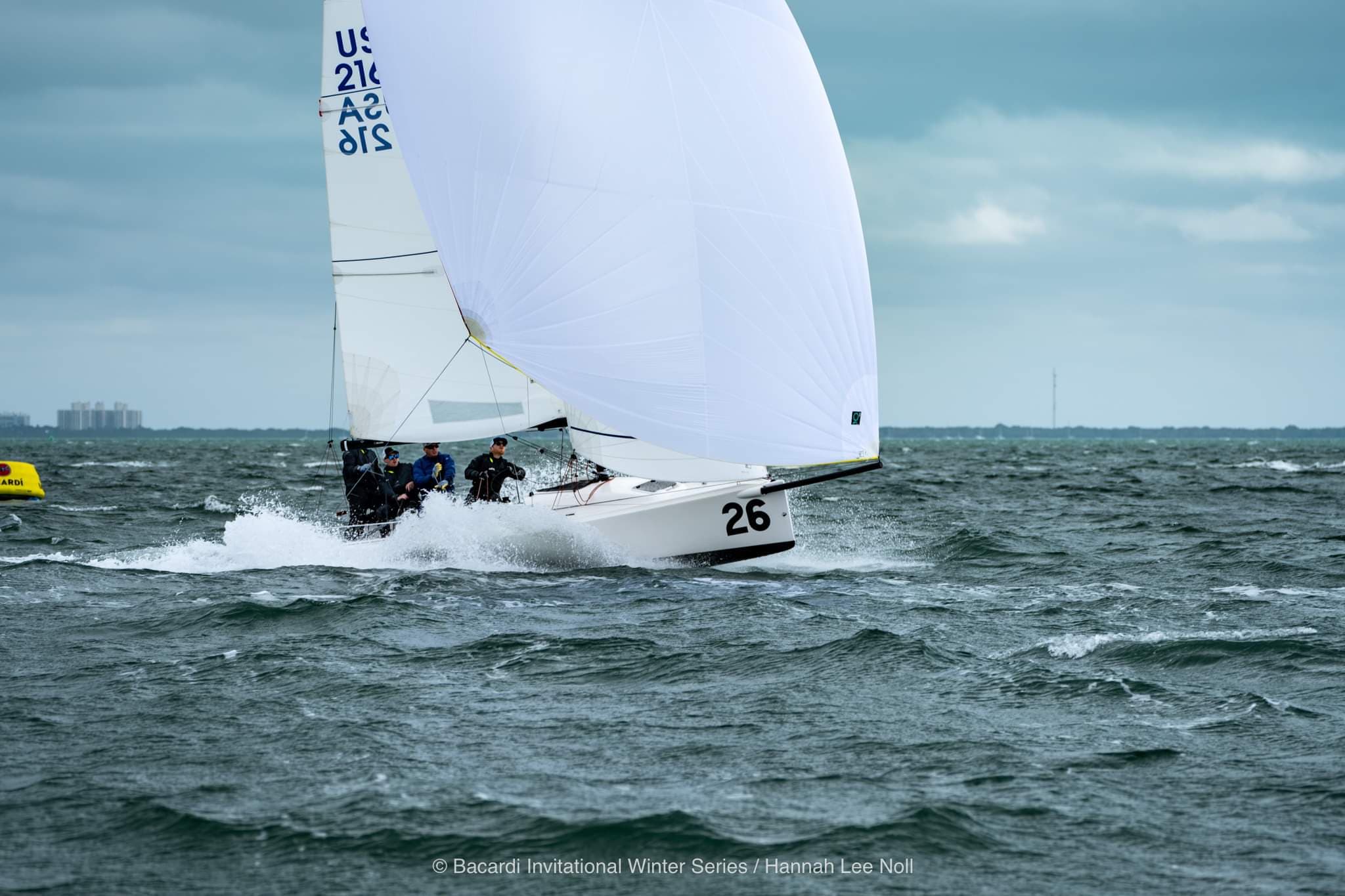 Four people on a sailboat with a spinnaker up